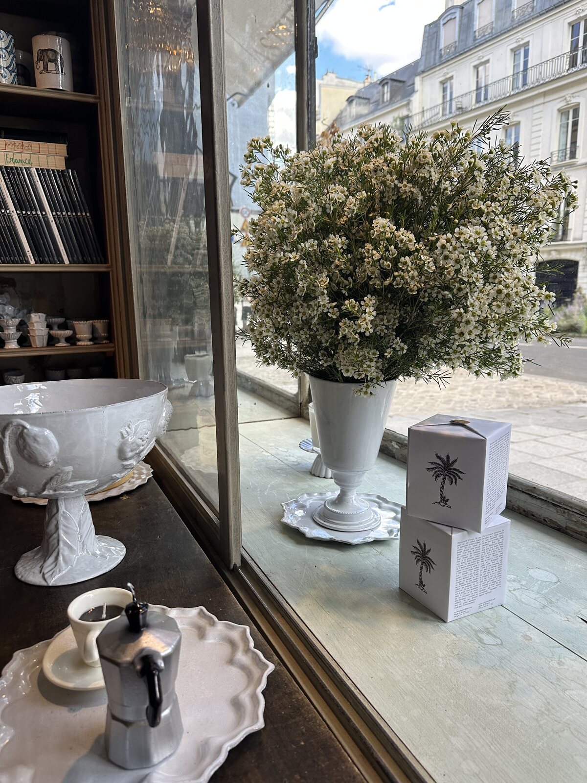 Installation florale FLWR Pro en vitrine de boutique, composition de fleurs de cire